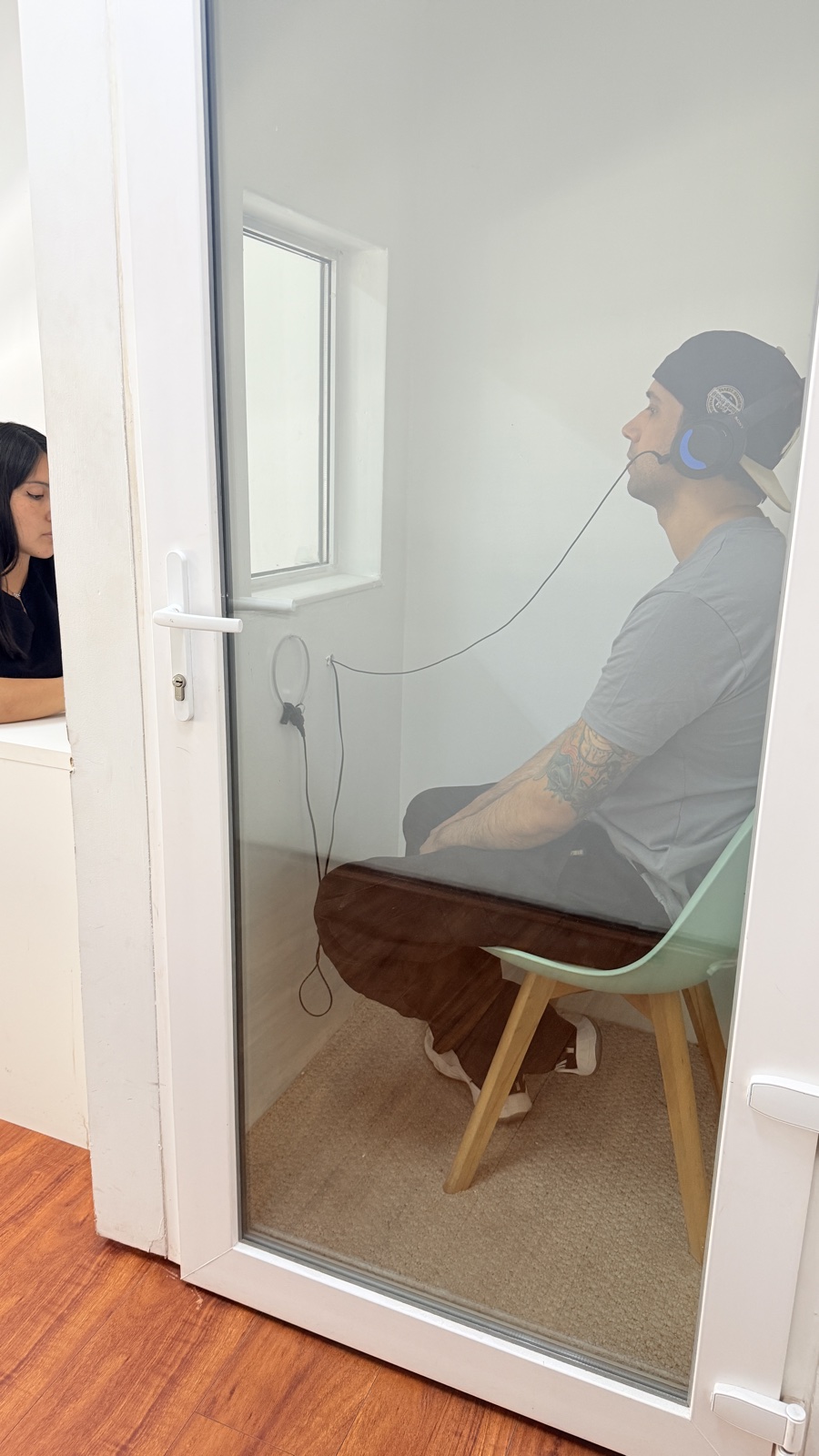 Paciente realizando audiometría en cabina sonoamortiguada con audífonos