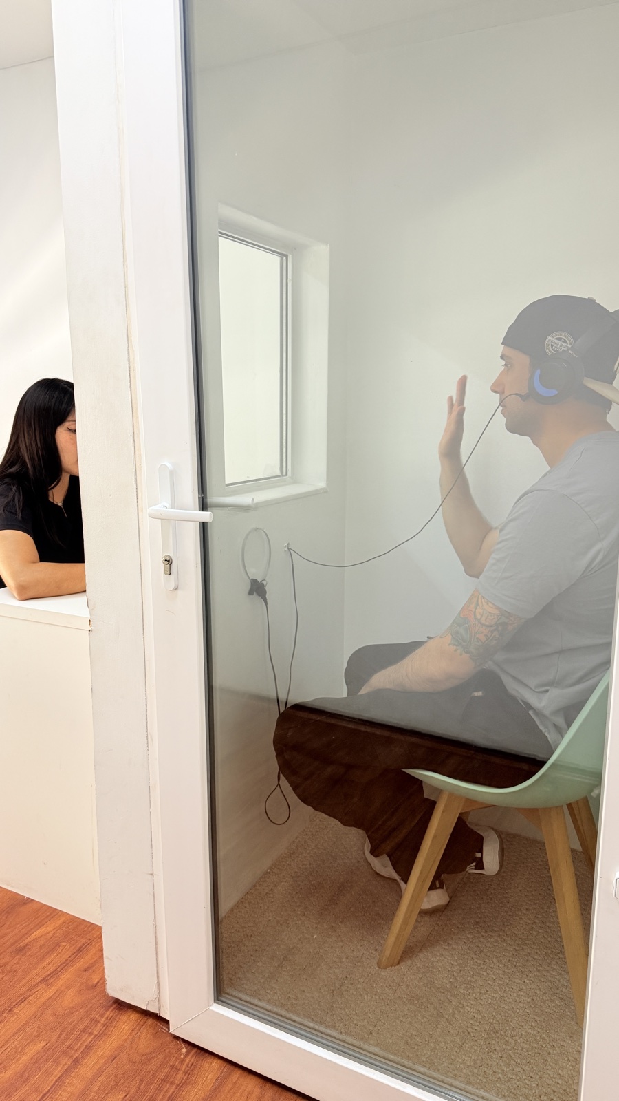 Paciente respondiendo durante examen auditivo en cabina profesional